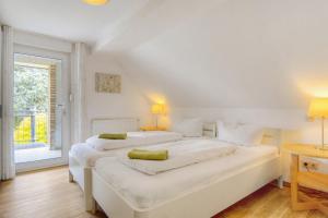 Göckes Haus Und Garten Rosengarten في Wettringen: سريرين في غرفة بيضاء مع نافذة