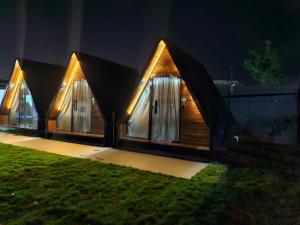 een huis met drie ramen in het gras 's nachts bij Chale suite privativo cafe e hidro in Sao Jose do Rio Preto