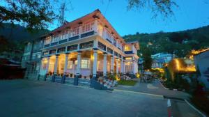 a large white building with lights on at Belvedere Palace Nainital in Nainital