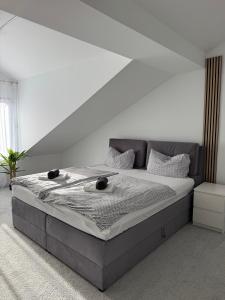 ein Bett in einem Schlafzimmer mit einer weißen Wand in der Unterkunft Rednitz Luxus House in Rednitzhembach