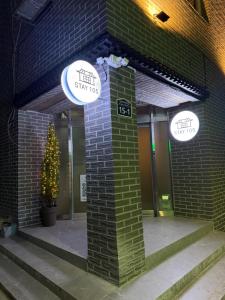 a brick building with a sign that says think tiny ways at stay105행궁 in Suwon