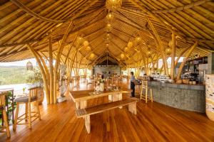 a large room with a table and a bar at Ketanu Bamboo Lodge Sumba in Praikalogu