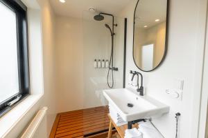 a bathroom with a white sink and a mirror at Van Heeckeren City Centre Studios Nes in Nes +8 photos
