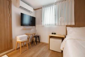 a bedroom with a bed and a table and a tv at stay105행궁 in Suwon