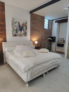 a bedroom with a large white bed with a painting on the wall at Apartment zu Hofe in Oberursel +46 photos