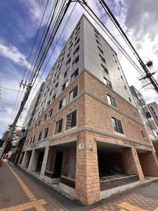 a tall brick building on the corner of a street at 401好立地札幌駅徒歩7分と大通駅徒歩6分で都心を満喫で綺麗な部屋で快適が生活が実現 in Sapporo