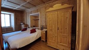 a bedroom with a bed and a large wooden cabinet at Bella Cortina - comodo al centro e impianti, con garage in Cortina dʼAmpezzo