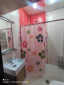 Un baño con cortina de ducha y lavabo. en Urban Inn Hostel, en Baku