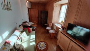 a living room with a couch and a flat screen tv at Bella Cortina - comodo al centro e impianti, con garage in Cortina dʼAmpezzo