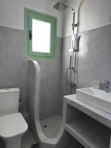 a bathroom with a sink and a toilet and a window at Perseas in Naousa