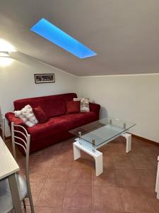 a living room with a red couch and a glass table at Eden Apartment di Manenti Andrea in Oltre il Colle