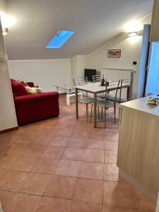 a living room with a table and a red couch at Eden Apartment di Manenti Andrea in Oltre il Colle