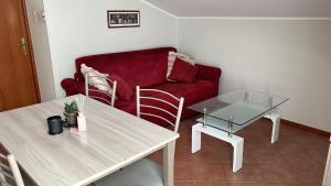 a living room with a red couch and a table at Eden Apartment di Manenti Andrea in Oltre il Colle