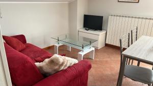 a living room with a red couch and a glass table at Eden Apartment di Manenti Andrea in Oltre il Colle +9 photos