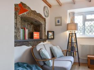 a living room with a chair and a fireplace at Rivendell Cottage in Liskeard