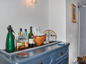 a counter with bottles on top of a blue dresser at Rivendell Cottage in Liskeard +16 photos