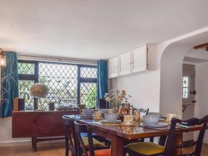 a dining room with a wooden table and chairs at Rivendell Cottage in Liskeard