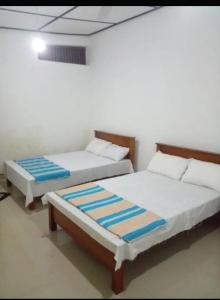 Dos camas una al lado de la otra en una habitación. en NK Hotel & Resturaunt, en Matale