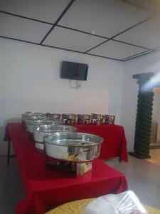 una hilera de mesas con manteles rojos en NK Hotel & Resturaunt, en Matale