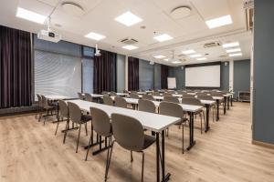 a classroom with tables and chairs in a room at Scandic Tampere City in Tampere