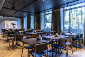 a restaurant with tables and chairs and large windows at Scandic The Mayor in Aarhus