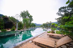 a pool with two benches next to a river at Vanlong garden in Kon Rung (1) +18 photos