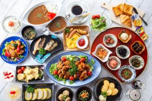 uma mesa cheia de pratos de alimentos com diferentes alimentos em Nest Hotel Kumamoto em Kumamoto