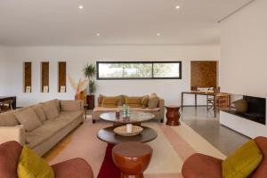 a living room with a couch and a table at Modern villa - 4 luxury suites - Golf Amelkis - Marrakech in Marrakech