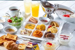 uma mesa com uma bandeja de alimentos e bebidas para o pequeno-almoço em Nest Hotel Kumamoto em Kumamoto
