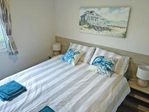 Un dormitorio con una cama con almohadas azules y blancas. en Lapras, en Porchfield