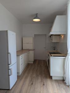 a kitchen with white appliances and wooden floors at L appart de la Petillerie in Roullet +10 photos