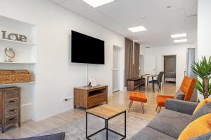 a living room with a couch and a tv on a wall at City Apartment in Uelzen