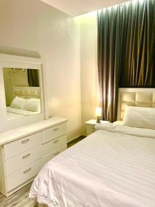 a bedroom with a white bed and a mirror at شقة 9 in Al-Safa