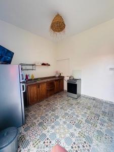 a kitchen with a refrigerator and a tile floor at Sunrise Camp in Mirleft +29 photos