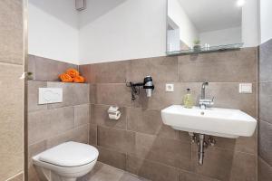 a bathroom with a toilet and a sink at City Apartment in Uelzen +15 photos