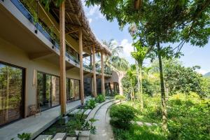 an exterior view of a building with trees and grass at Vanlong garden in Kon Rung (1)