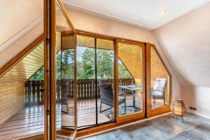 a room with glass doors and a balcony with a table at Fewo Lütt Stuv in Fockbek