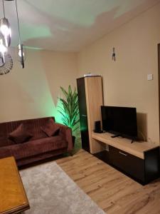 a living room with a couch and a flat screen tv at Grand Albi Apartament in Gjakove