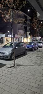 a group of cars parked on a city street at night at Grand Albi Apartament in Gjakove