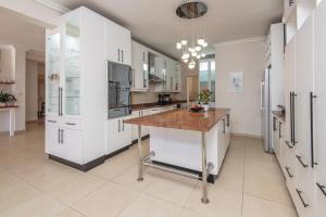 a kitchen with white cabinets and a wooden counter top at The Beach Palace Ramsgate in Margate