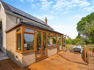 an extension to a house with a deck with glass doors at Halfstone House in Llanelli