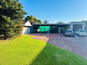 a house with cars parked in front of it at Little Oasis - Palm Room in Port Elizabeth