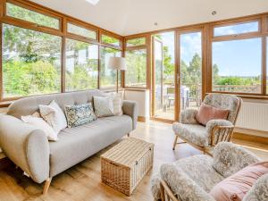 a living room with a couch and two chairs at Halfstone House in Llanelli