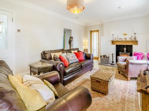 a living room with leather furniture and a fireplace at Halfstone House in Llanelli