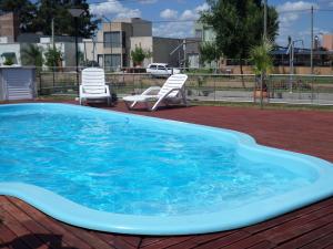 a large swimming pool with two chairs at Complejo Arami Apart in Colón