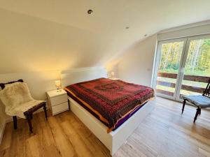 ein Schlafzimmer mit einem Bett und einem Stuhl und einem Fenster in der Unterkunft Elisabeth, Ferienwohnung in Wesseloh