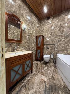 a bathroom with a tub and a sink and a toilet at Дельмар Люкс in Dnipro