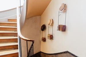 Ein Flur mit Treppe, an dessen Wand Gepäckstücke hängen. in der Unterkunft La Poterne l Maison d'hôtes à Epernay in Rouen