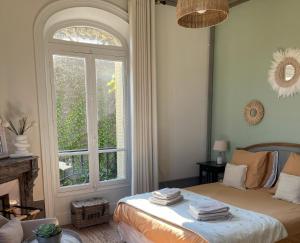 ein Schlafzimmer mit einem Bett mit einem großen Fenster in der Unterkunft La Poterne l Maison d'hôtes à Epernay in Rouen