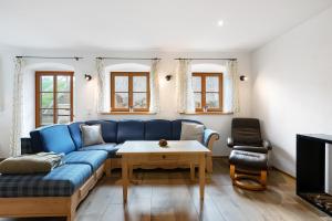 a living room with a blue couch and a table at Ferienhaus Region Tegernsee in Eben